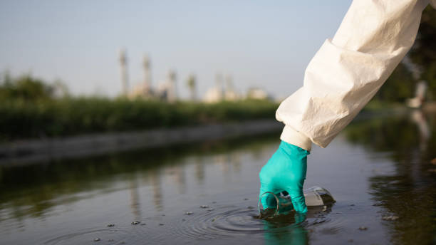 istock environmentalist use a chemical flask to collect the  samples of toxic water for testing and check with quality of water from industrial 2149301609