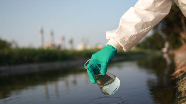 istock Close-up scientist or environment engineer's hand with a chemical protective suit and PPE collect a sample of toxic wastewater from a chemical flask  from an industrial 2149301665