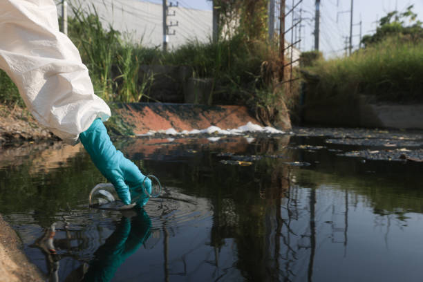 istock Close-up scientist or environment engineer's hand with a chemical protective suit and PPE collect a sample of toxic water from an industrial waterway 2149301672