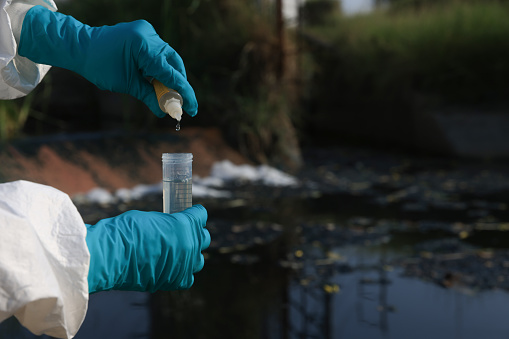 Environmental Scientist Examining Wastewater from factory at industrial estate
