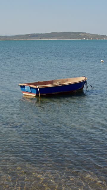 Blue small fishing boat anchored