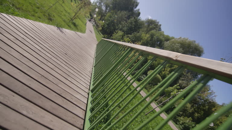 Wooden boardwalk with handrails surrounding city park