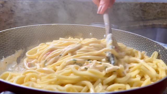 Mixing the pasta with the special white sauce