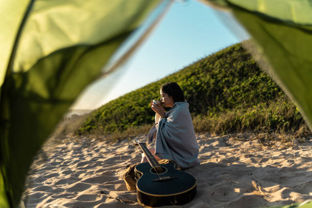 Young woman drinking coffee on the beach