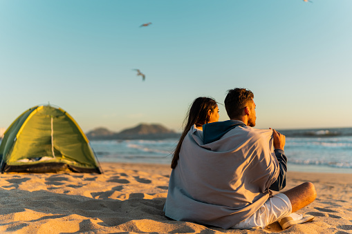 Couple embraced looking at view on beach
