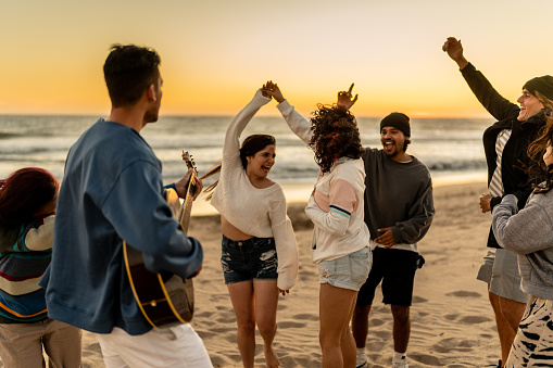 Friends dancing and having fun on the beach