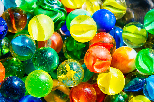 A handful of playing marbles with one in focus