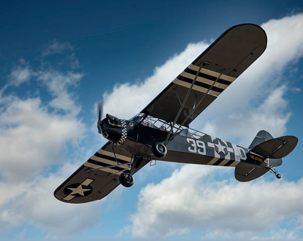 A beautifully restored L-4 Grasshopper flies by at Massey Aerodrome, a small grass field on Maryland’s Eastern Shore.The L-4 Grasshopper is a light observation and liaison aircraft that served with distinction during World War II. Developed by Piper Aircraft Corporation, the L-4 Grasshopper was a militarized version of the Piper J-3 Cub, a popular civilian aircraft of the era.The primary role of the L-4 Grasshopper was observation, reconnaissance, and liaison duties. It was used for artillery spotting, aerial photography, courier missions, and communication tasks, providing vital support to ground troops.The L-4 Grasshopper saw extensive service during World War II, serving with the U.S. Army Air Forces, the U.S. Navy (as the NE-1), and other Allied air forces. It played a vital role in numerous campaigns, including the D-Day invasion of Normandy, the Battle of the Bulge, and the Pacific island-hopping campaign.