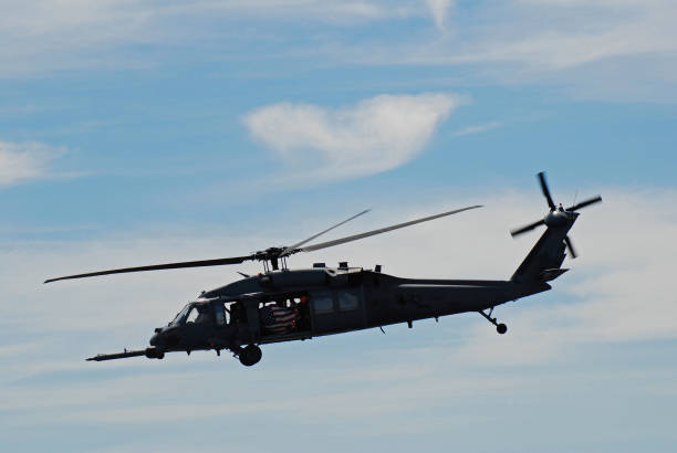 Wantagh, NY, USA May 23 An armed service member holds the American flag as a military Blackhawk helicopter flies through the skies over Wantagh, New York