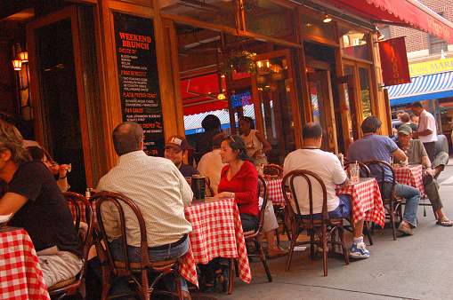 New York, NY, USA July 11 A large group of people enjoy their al fresco dining on a summer evening at a restaurant in the Greenwich Village neighborhood of New York city