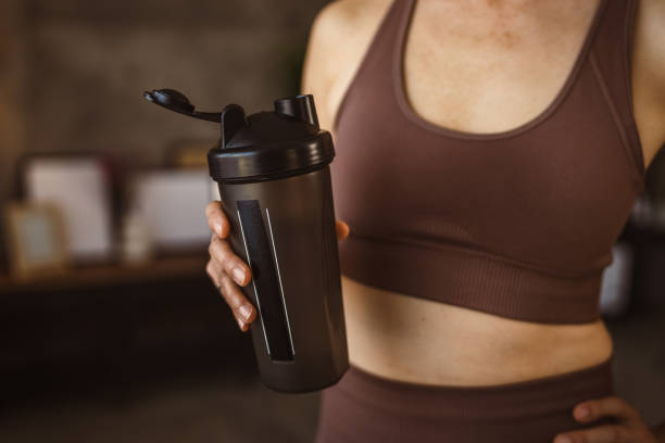 istock unknown woman hold supplement shaker take a break from training 2149317833