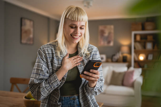 istock Young woman text message and browse internet on mobile phone at home 2149318259