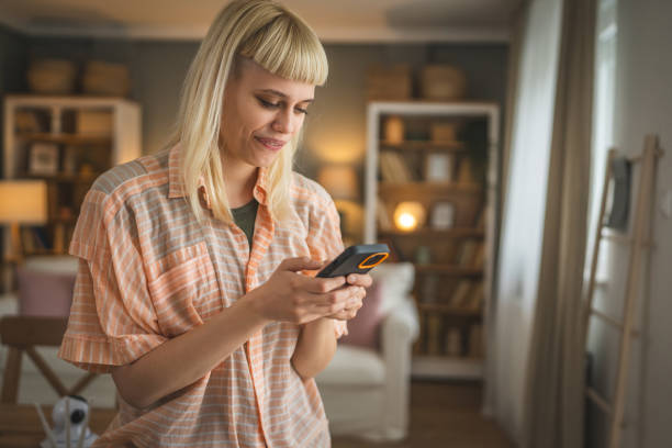 istock Young woman text message and browse internet on mobile phone at home 2149318822