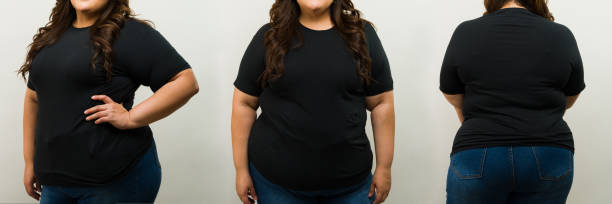 istock Confident plus-size woman in black tee and jeans poses from various angles in a studio setup for a t-shirt mockup 2149319140