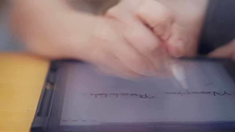 A person is writing on a tablet with a white pen