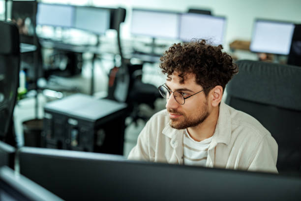 istock Young handsome man working on desktop PC at the office 2149321214