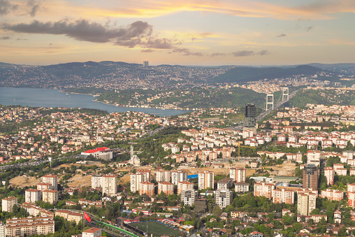 A panoramic sunset casts a warm glow over Istanbuls cityscape and the Bosphorus Strait, showcasing the urban and natural beauty. Photo taken from Istanbul Sapphire tower, Turkey