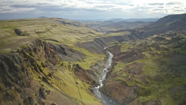 River Coursing Through the Rugged Terrain Near Haifoss Waterfall in Iceland - Drone Flying Forward
