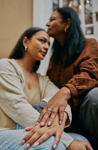 The hands of a mother and daughter rest gently on each other. A symbol of connection and unity. Stock photo