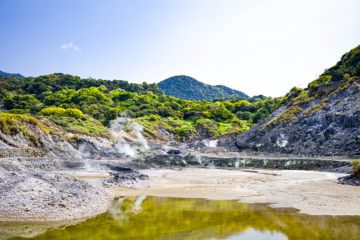 the contrasting elements of Beitous Sulphur Valley, where the lush greenery meets the rugged terrains emanating steam