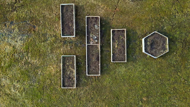 Hexagonal And Rectangular Raised Garden Beds On Field. overhead, zoom-out shot