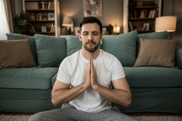 istock Mid adult man meditating at home. 2149331859