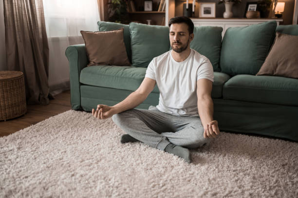 istock Mid adult man meditating at home. 2149331906