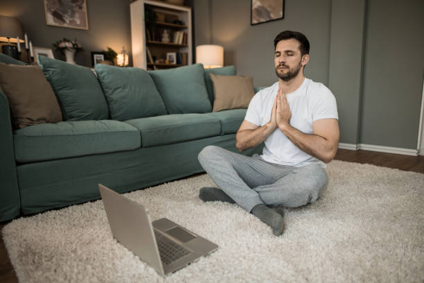 istock Mid adult man meditating at home. 2149331996
