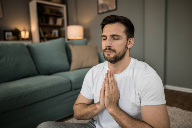 istock Tranquil man doing yoga and meditating at home. 2149332093