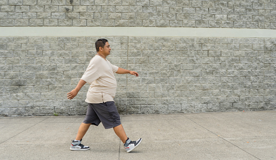 young man wearing comfortable clothes and walking for his exercise routine