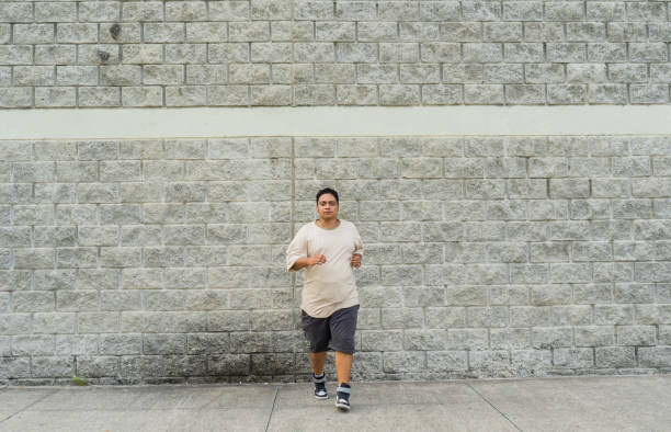istock thick-framed Latino male running and training in the park 2149334660
