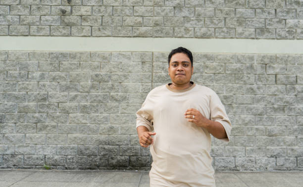 A courier holding a package and running to make a delivery.  