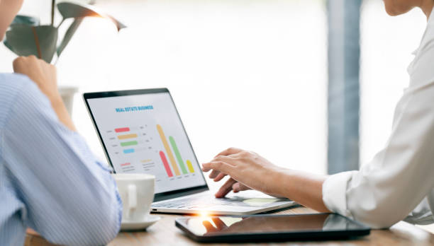 istock Young colleagues discuss business and analytical price charts using tablet and laptops to calculate financial, tax, accounting, statistics and analytical research ideas. 2149336068