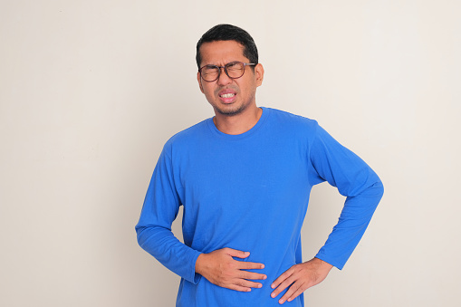 A man touching his stomach showing in pain expression