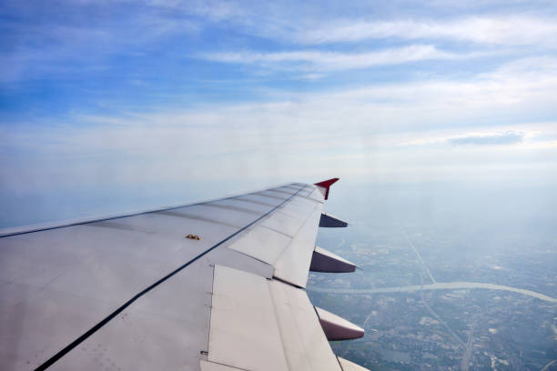 istock a view from airplane window that has a wing with red winglet in the sky with cloud and city below 2149338222