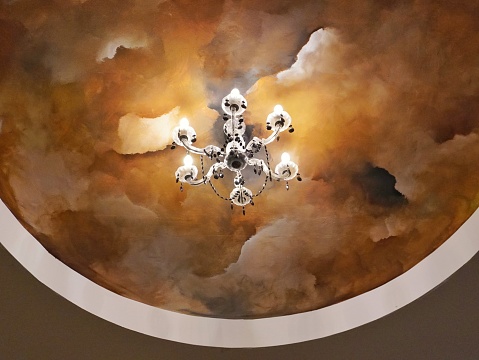Ceiling mural illuminated by a chandelier