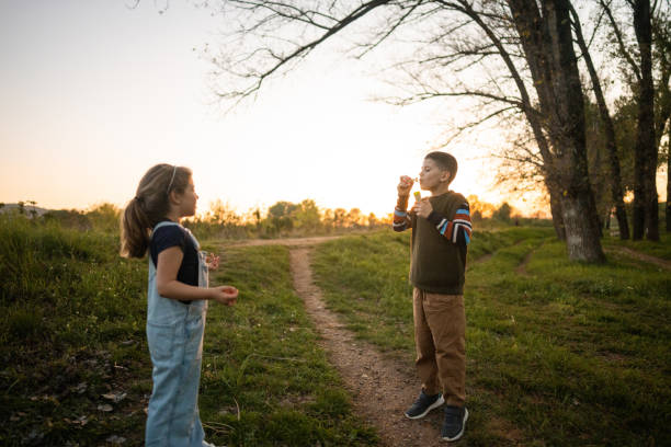 istock Brother and sister playing with soap bubbles 2149341203