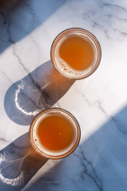 Two glass of homemade Kombucha on the marble table, fermented tea beverages in the sunlight.