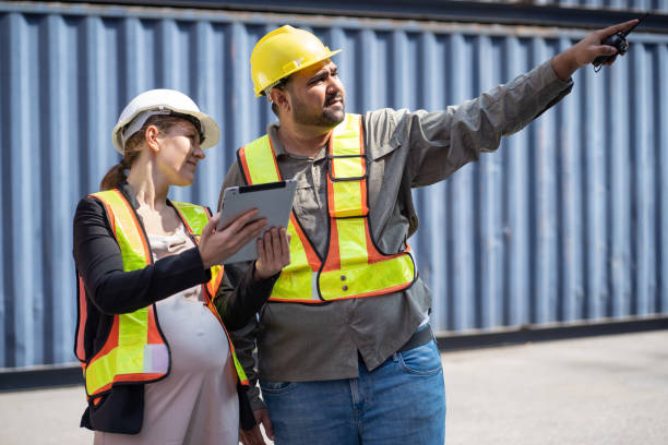 istock Middle east logistic worker foreman finger point with caucasian logistic worker pregnant woman at container site 2149343501