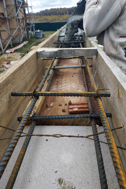 istock Worker lines concrete in formwork with trowel, construction of new home. 2149343537