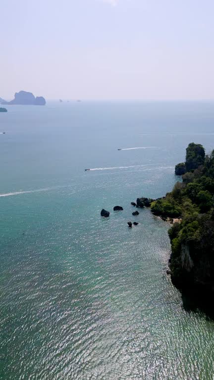 Railay Beach, Krabi Thailand with giant cliffs next to ocean. Boats. Vertical Video. HD