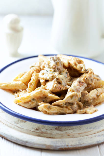 istock Penne Pasta baked with Meat on bright wooden Background. 2149343938