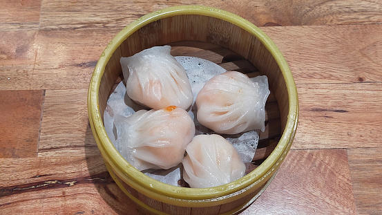 Steamed Hakao Dimsum in Bamboo Basket on Rustic Wooden Table