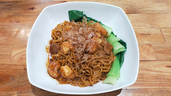 Penang famous street food, wok-fried rice noodles with scallop, egg, bean sprouts, prawns, chives, soy sauce and chili paste.
