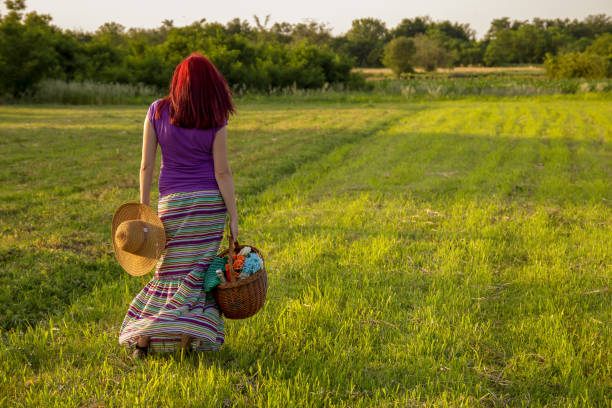 Young woman carrying picnic baskets in park