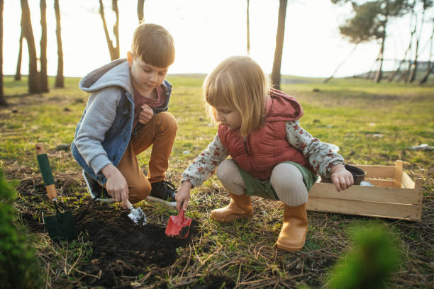 istock Children planting trees outdoors in springtime 2149349775
