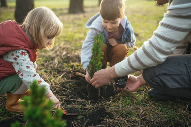 istock Father and children planting trees outdoors in springtime 2149349795