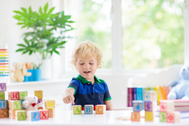 istock Child learning letters. Kid with wooden abc blocks 2149350293