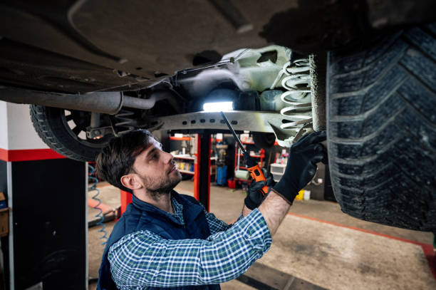 Car mechanic fixing or checking the car in workshop
