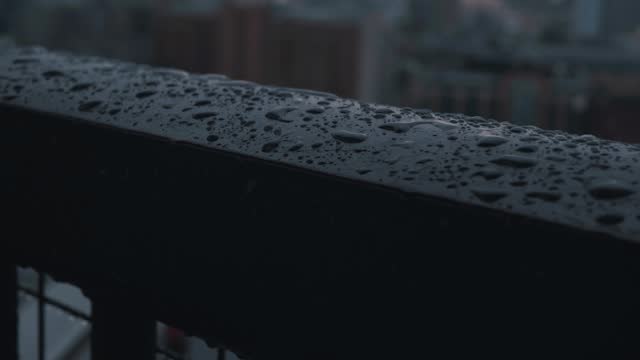 Drops of rain falling and splasing onto the stainless steel fence of the balcony. stock video